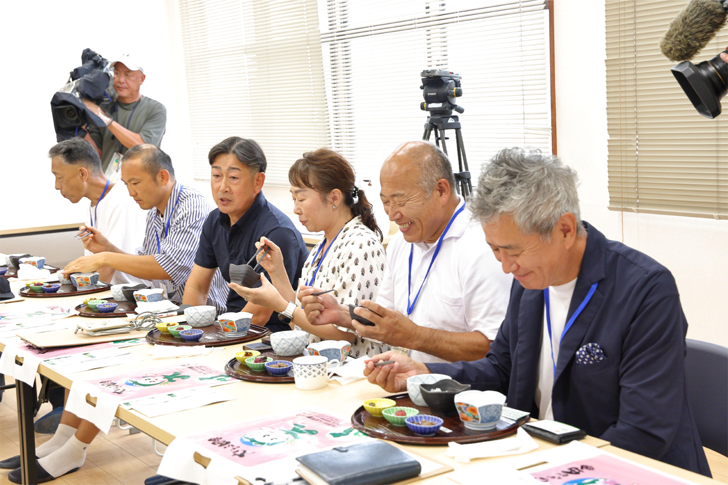 生産者の鈴木さん（写真奥から3人目）の話を聞きながら真剣に試食をし、満足そうな表情を見せる参加者。